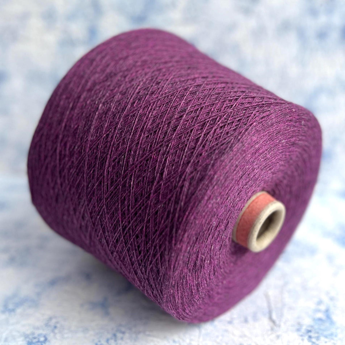 Rich violet melange yarn with a subtle sheen, fine twist, and delicate halo, showcasing the luxurious cashmere silk blend.