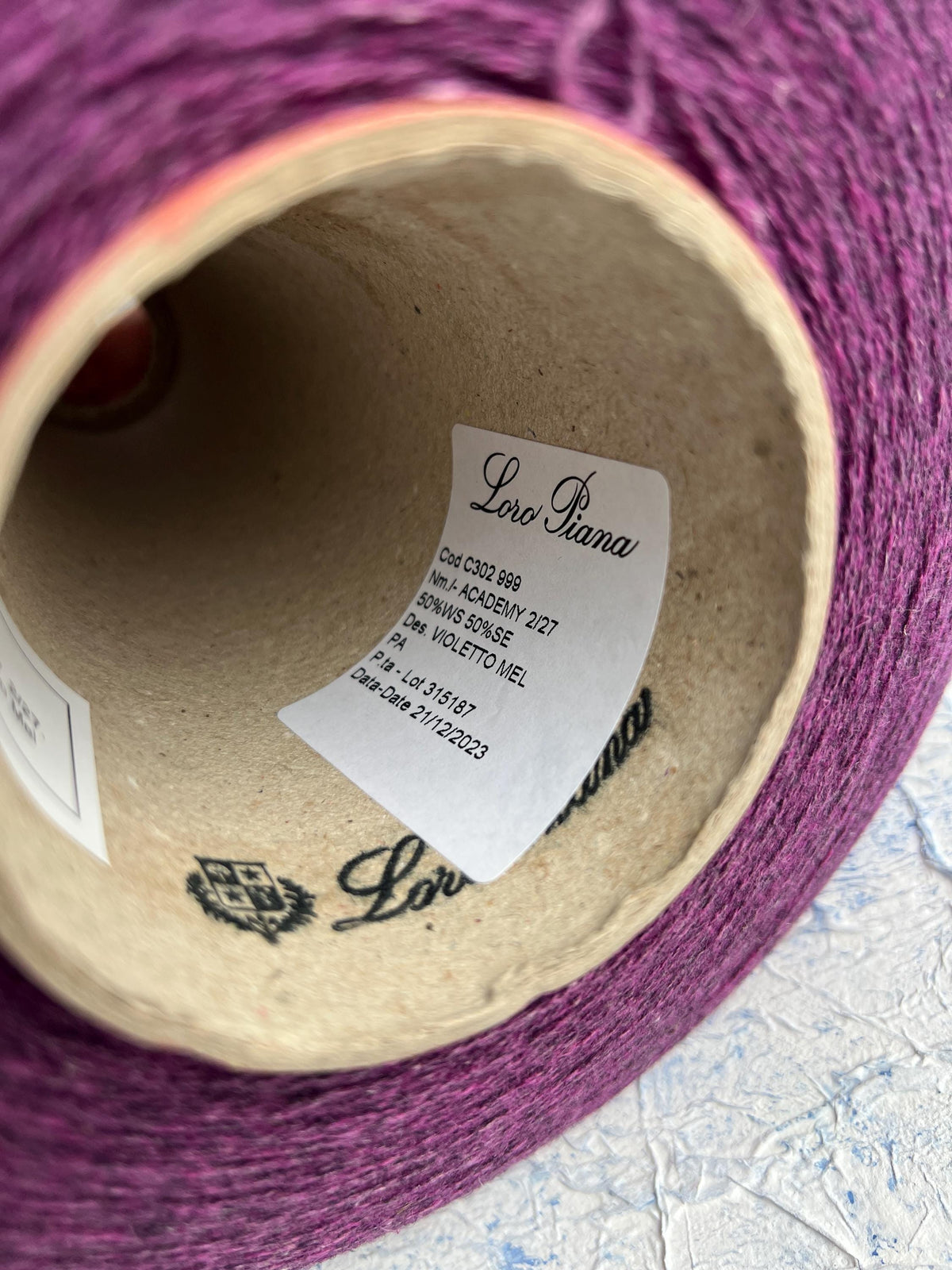 Rich violet melange yarn with a subtle sheen, fine twist, and delicate halo, showcasing the luxurious cashmere silk blend.