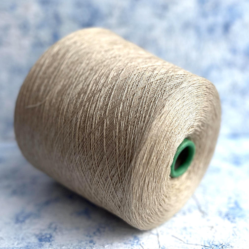 Close-up of a skein of fine, undyed lace weight yarn, showcasing its subtle sheen, delicate two-ply twist, and soft, ethereal halo.