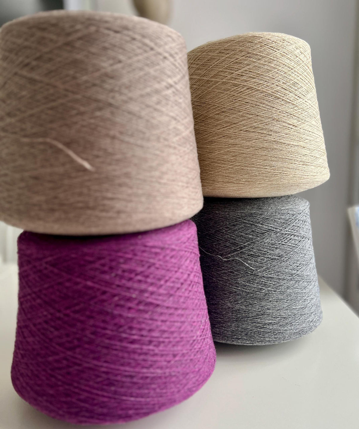 Close-up of a skein of fine, undyed lace weight yarn, showcasing its subtle sheen, delicate two-ply twist, and soft, ethereal halo.