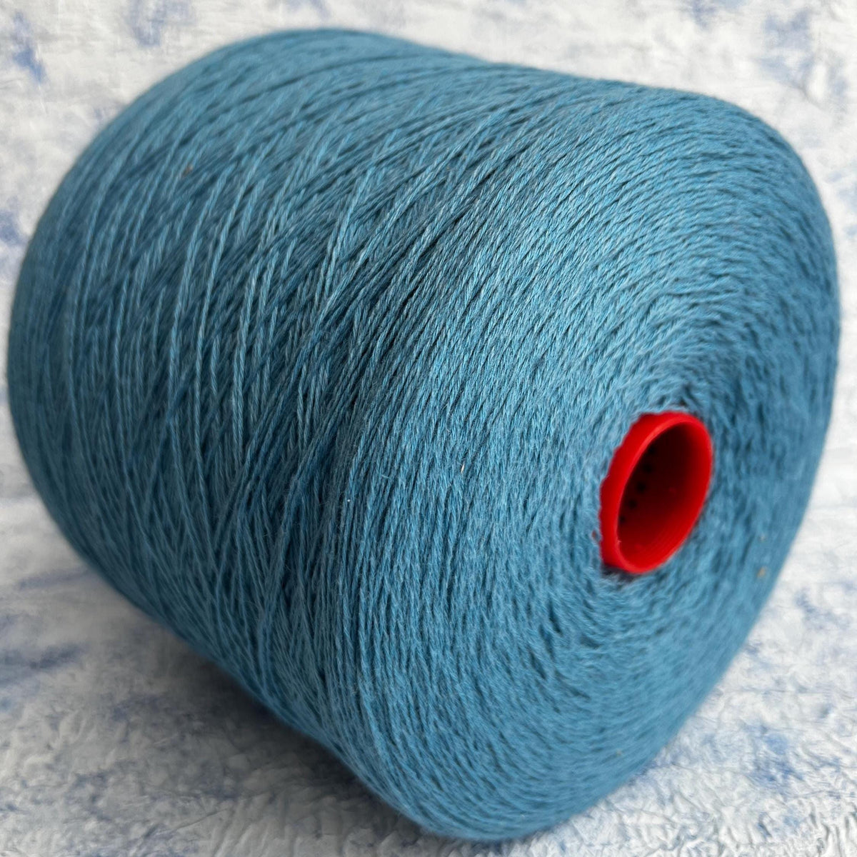 A vibrant, deep blue yarn, showcasing a smooth, uniform twist with a subtle natural sheen, ready for luxurious crafting.