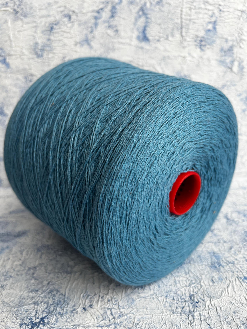 A vibrant, deep blue yarn, showcasing a smooth, uniform twist with a subtle natural sheen, ready for luxurious crafting.