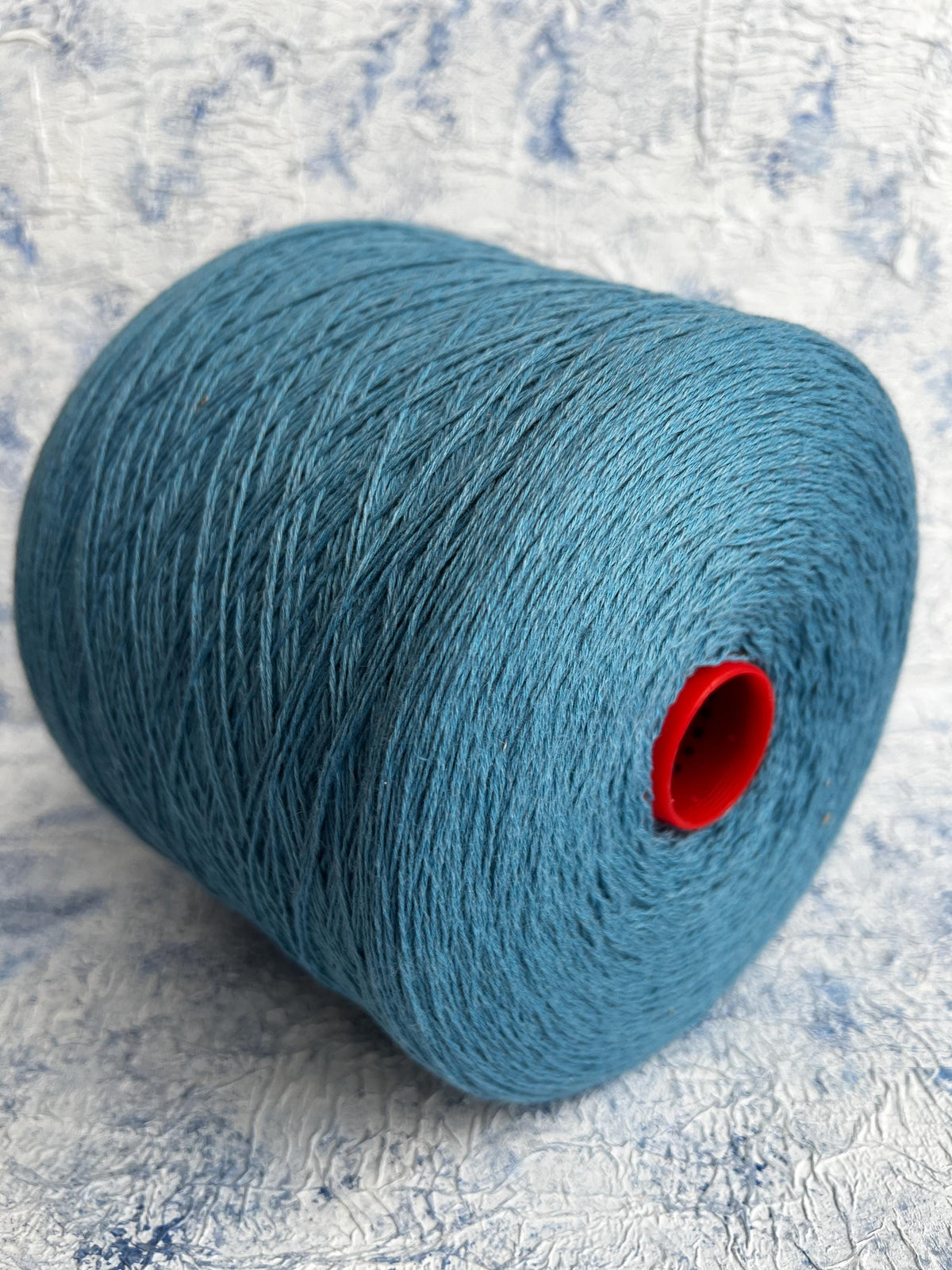 A vibrant, deep blue yarn, showcasing a smooth, uniform twist with a subtle natural sheen, ready for luxurious crafting.