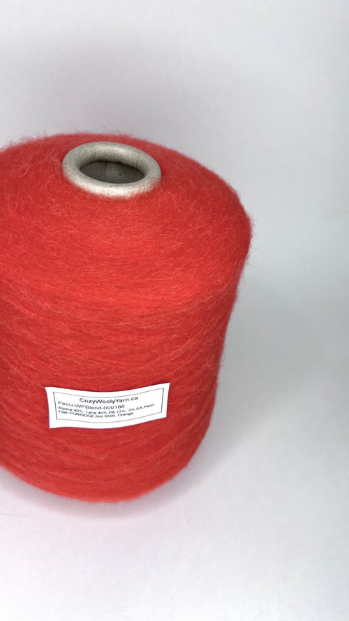 Luxurious orange yarn, soft with a subtle 'porridge' heathered texture. Features a delicate alpaca halo, gentle sheen, and a fine, even single-ply twist.