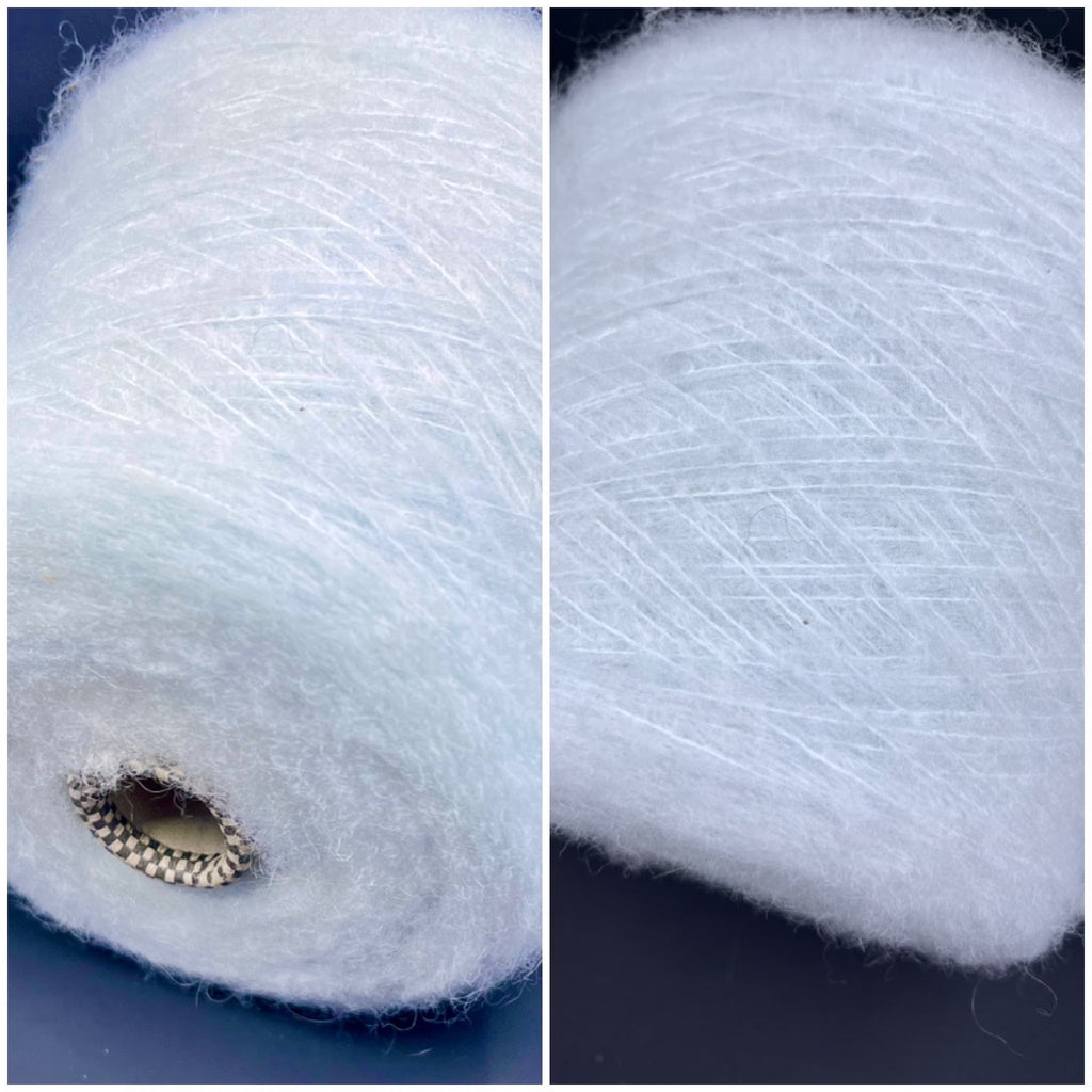 A delicate skein of pale mint green luxury yarn, exhibiting a fine, consistent twist, subtle sheen, and a soft, slightly fuzzy texture.