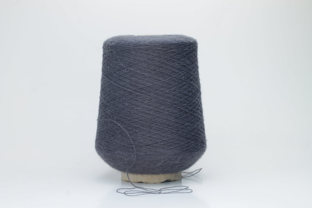 Soft, heathered gray luxury yarn, gently twisted, with a delicate alpaca halo and a subtle matte sheen, ready for knitting.