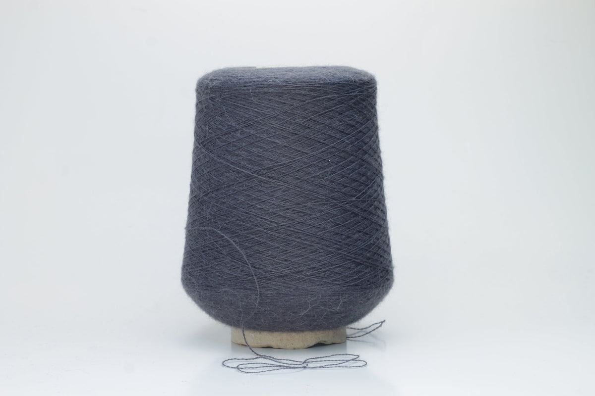 Soft, heathered gray luxury yarn, gently twisted, with a delicate alpaca halo and a subtle matte sheen, ready for knitting.