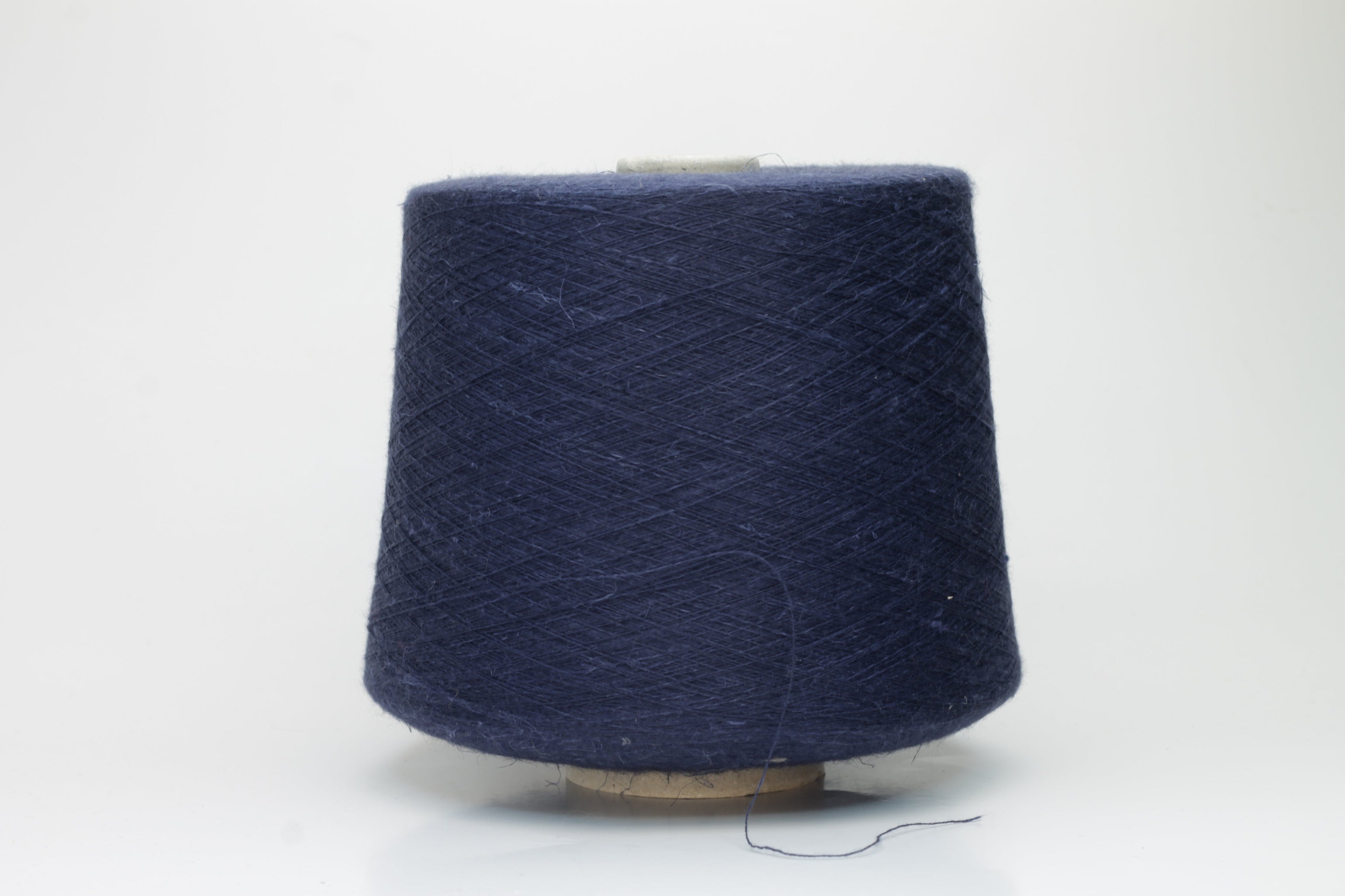 A finely plied, three-strand yarn in a deep, rich dark blue. The smooth threads exhibit a subtle, lustrous sheen under light.