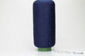 A tightly twisted, smooth two-ply thread of deep indigo blue, glistening with a high-luster sheen, wound onto a symmetrical cone.