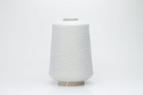 A close-up of soft, matte beige yarn, meticulously twisted into a fine 2-ply strand, showcasing its subtle fluffiness and consistent texture. The natural, warm hue is uniform throughout.