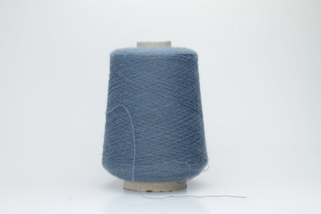 A skein of deeply saturated cerulean blue yarn, visibly soft with a subtle, plush halo. Features a fine, consistent two-ply twist structure.