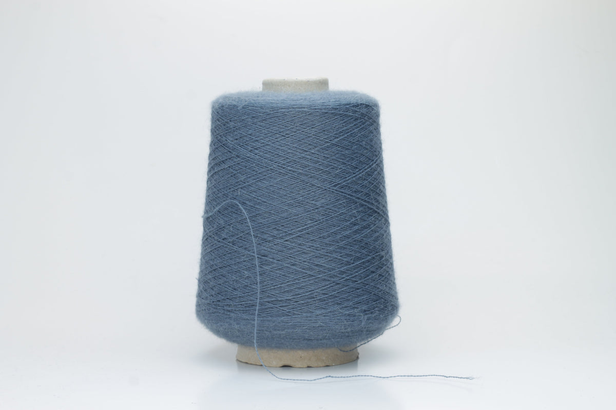 A skein of deeply saturated cerulean blue yarn, visibly soft with a subtle, plush halo. Features a fine, consistent two-ply twist structure.