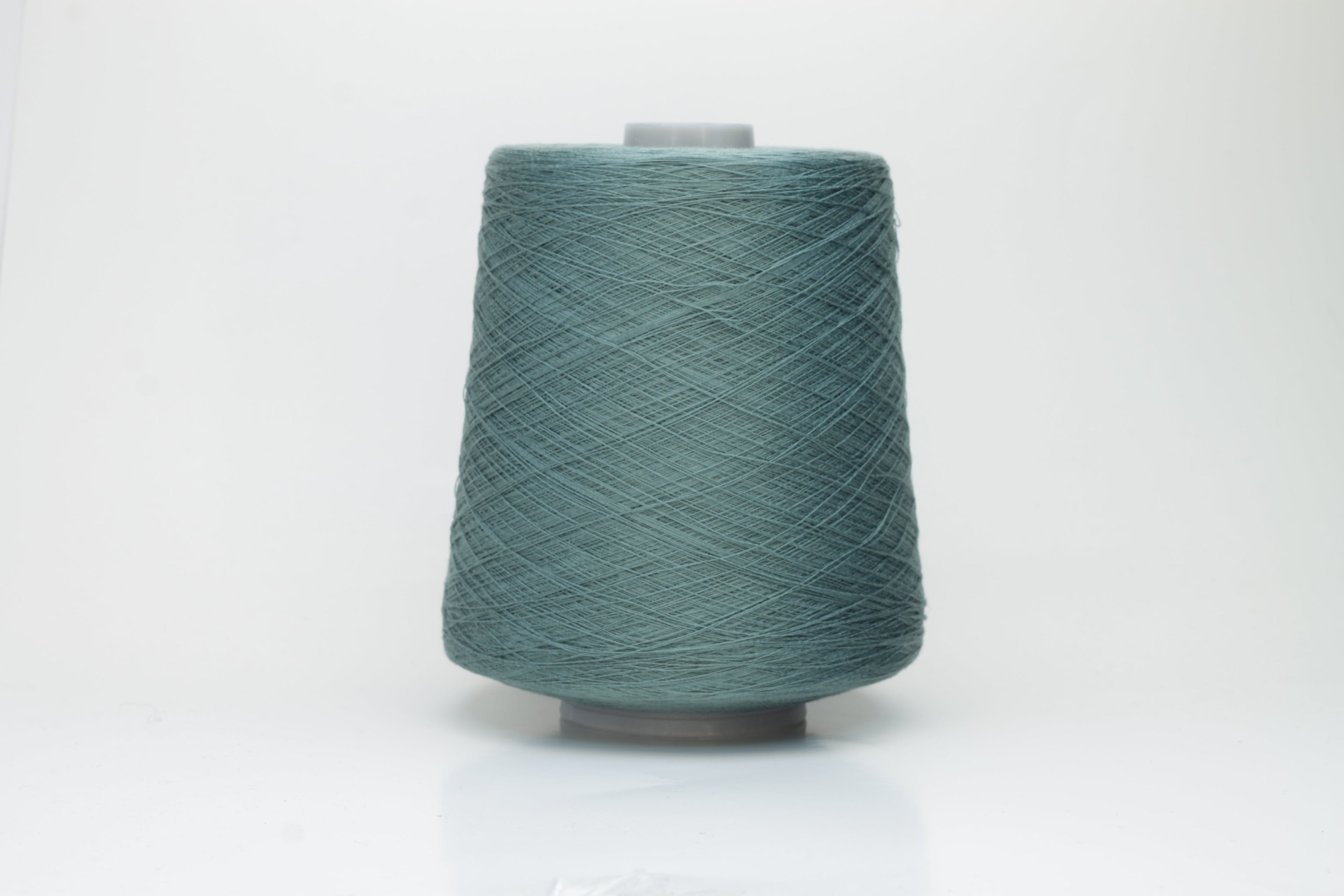 A finely spun skein of vibrant green silk cotton yarn with a subtle, natural sheen. The tight, smooth twist of the fibers is visible.