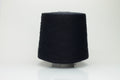 Close-up of a single strand of lustrous black yarn, its smooth, compact twist revealing subtle silk sheen over cotton fibers. The even ply suggests strength and a refined finish.