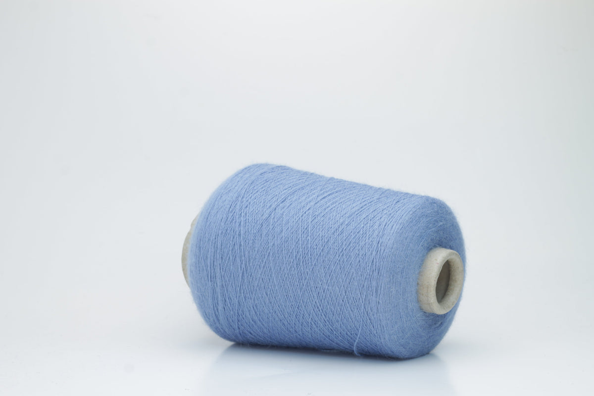 Close-up of a skein of soft, slightly fuzzy two-ply yarn in a deep, vibrant cerulean blue with a subtle, natural sheen.