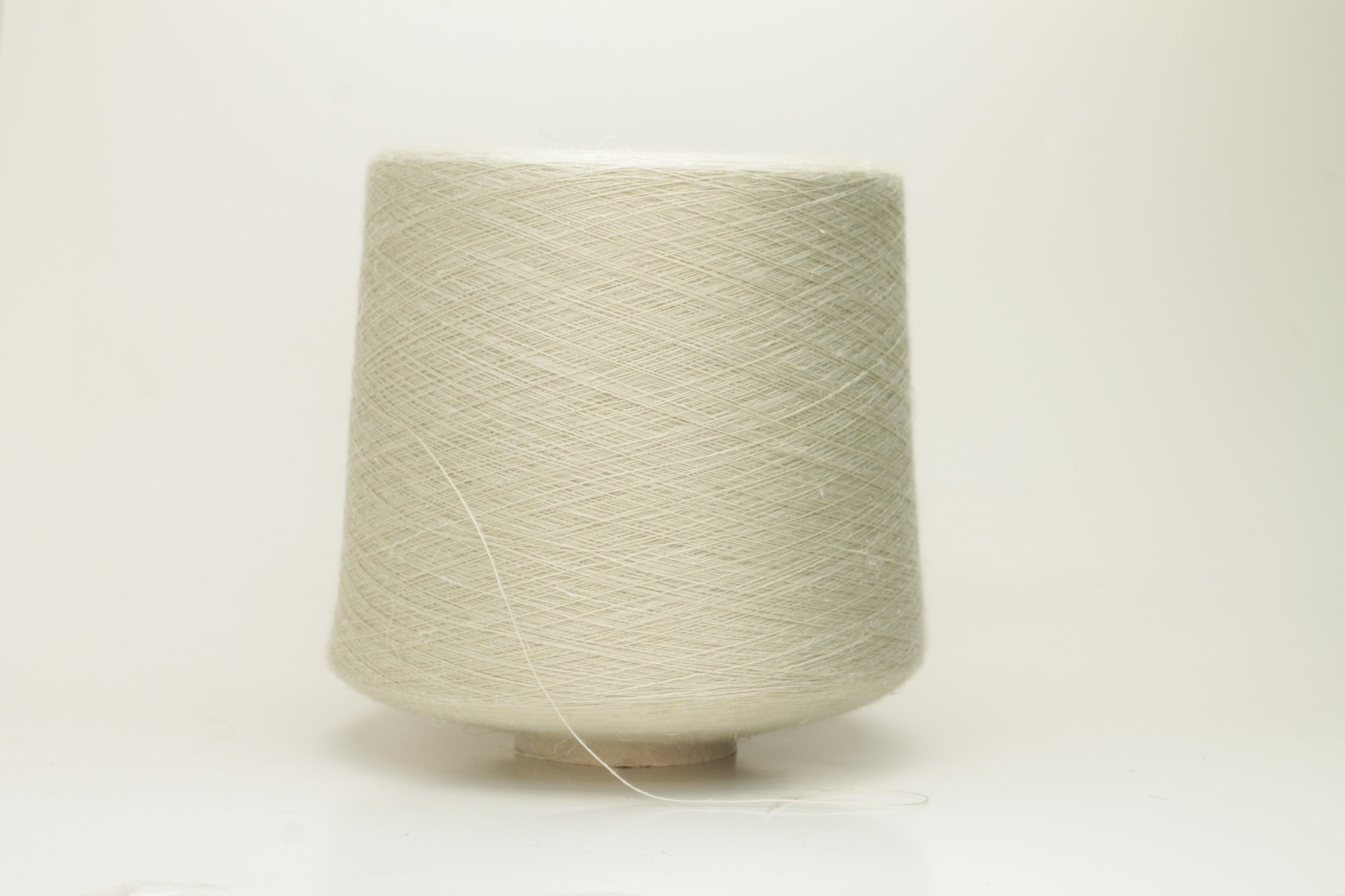 Close-up of a delicate, smoothly twisted light gray yarn strand, showing fine ply definition, subtle sheen, and gentle fluff.
