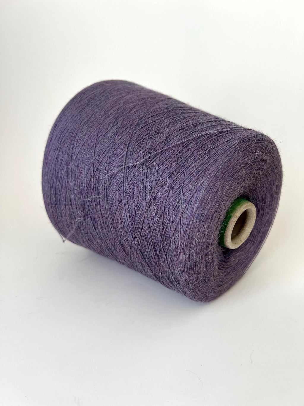 A lustrous skein of deep, rich violet yarn, visibly soft and fluffy with a delicate halo. The fibers show a subtle, luxurious sheen.