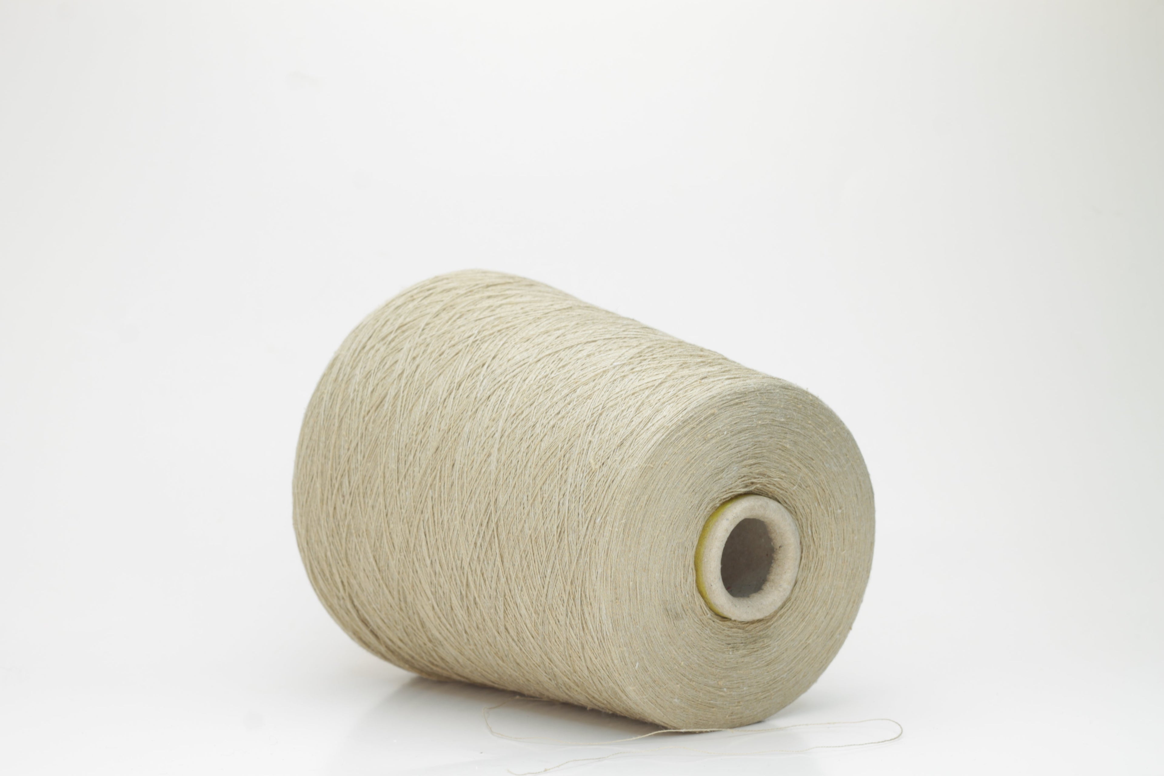 A skein of light beige yarn, showcasing a subtle sheen from the silk and a slight irregular texture from the linen fibers. The individual plies are gently twisted, creating a fluid, soft drape.