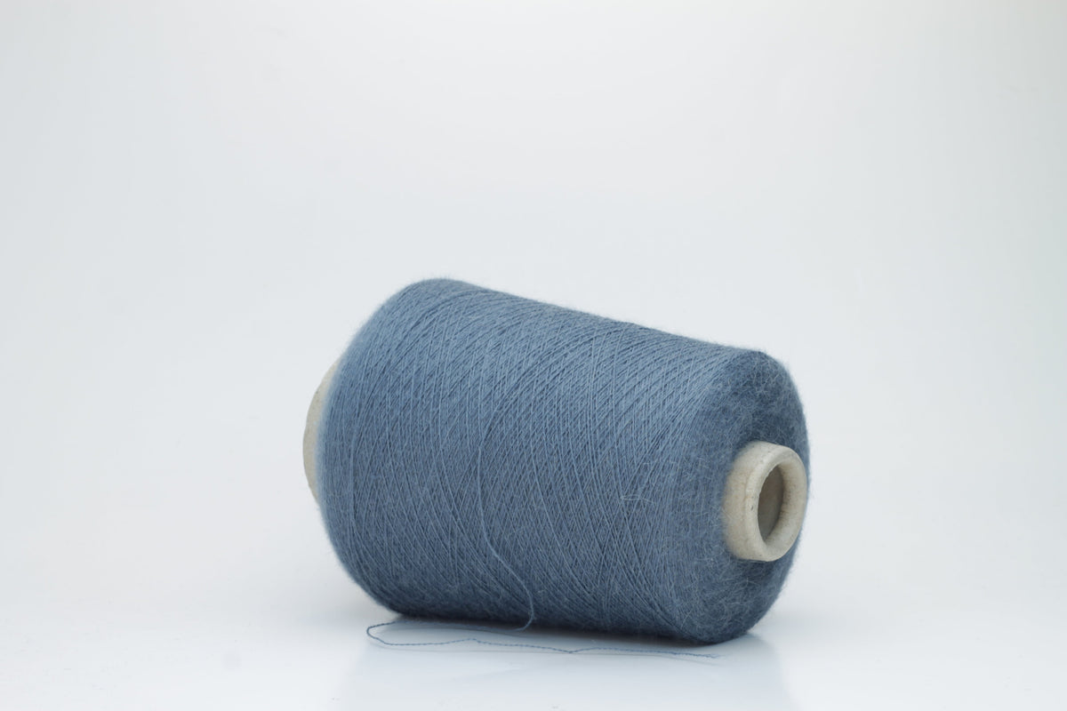 A skein of deeply saturated cerulean blue yarn, visibly soft with a subtle, plush halo. Features a fine, consistent two-ply twist structure.