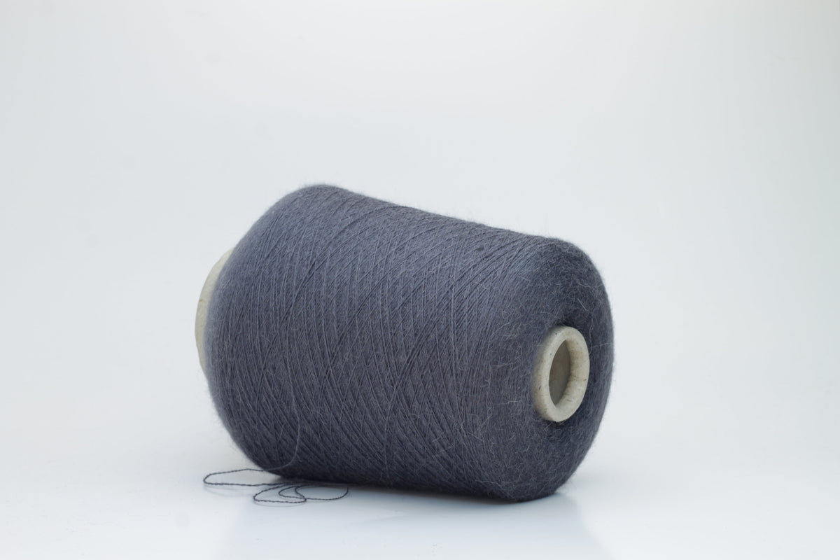 Soft, heathered gray luxury yarn, gently twisted, with a delicate alpaca halo and a subtle matte sheen, ready for knitting.