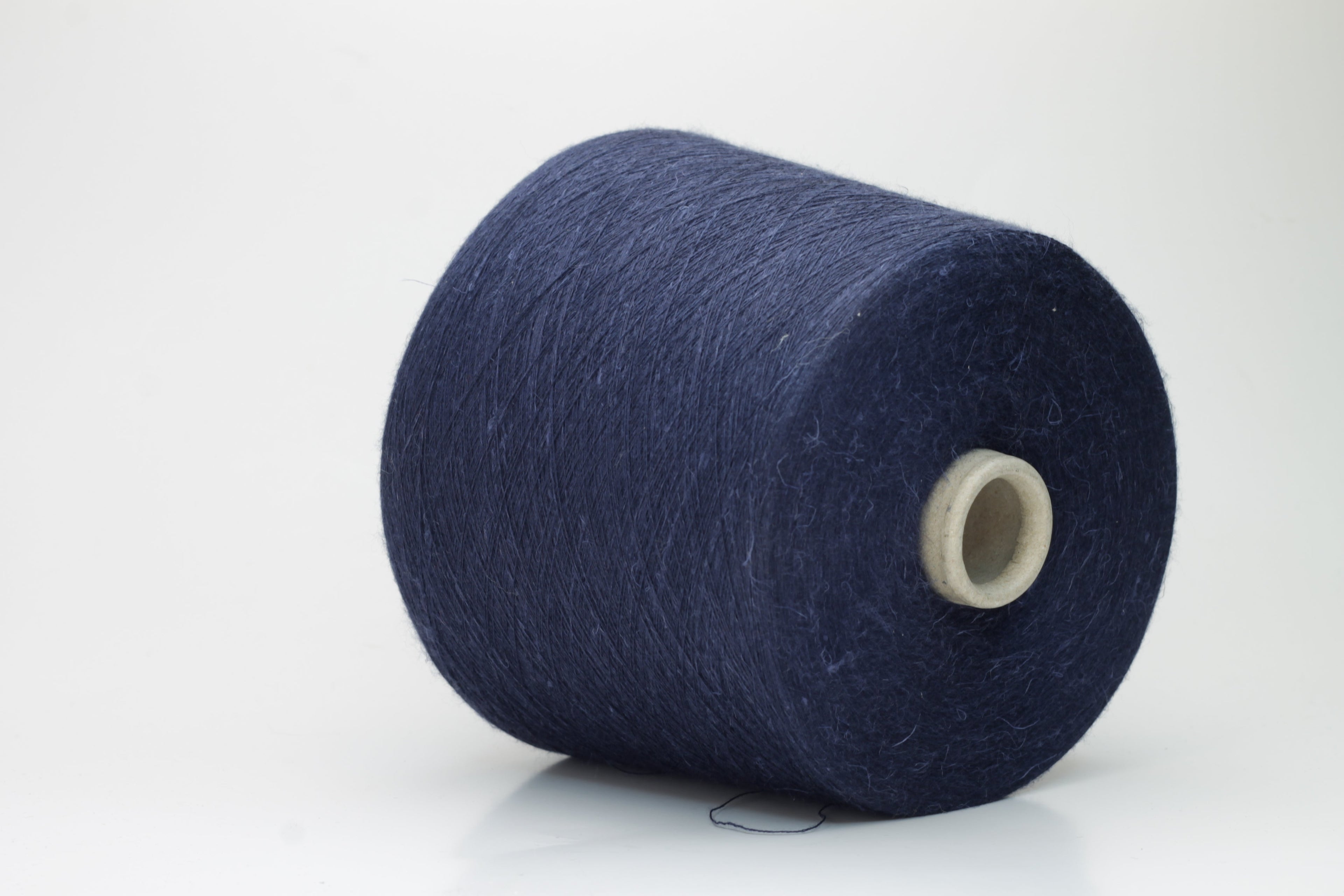 A finely plied, three-strand yarn in a deep, rich dark blue. The smooth threads exhibit a subtle, lustrous sheen under light.