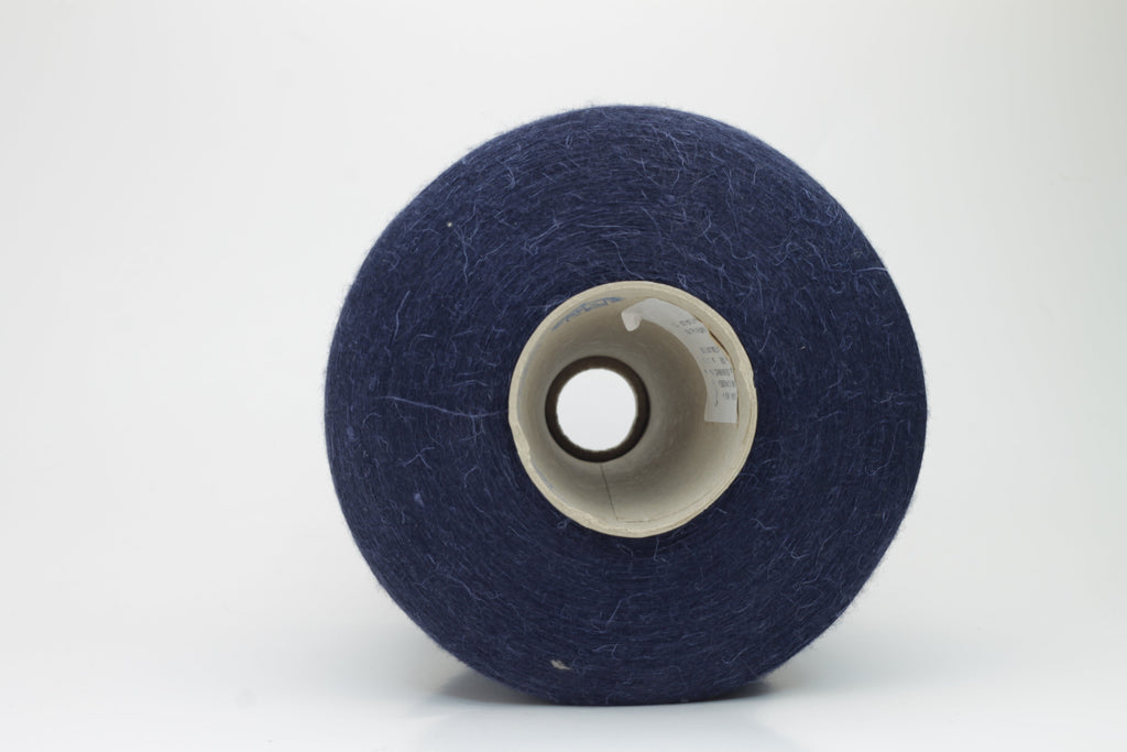 A finely plied, three-strand yarn in a deep, rich dark blue. The smooth threads exhibit a subtle, lustrous sheen under light.