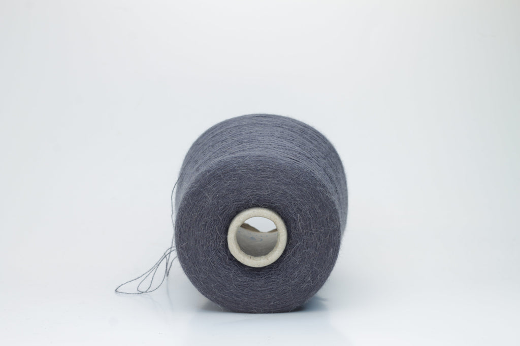 Soft, heathered gray luxury yarn, gently twisted, with a delicate alpaca halo and a subtle matte sheen, ready for knitting.