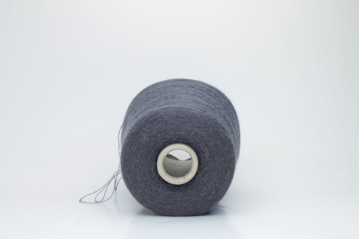 Soft, heathered gray luxury yarn, gently twisted, with a delicate alpaca halo and a subtle matte sheen, ready for knitting.