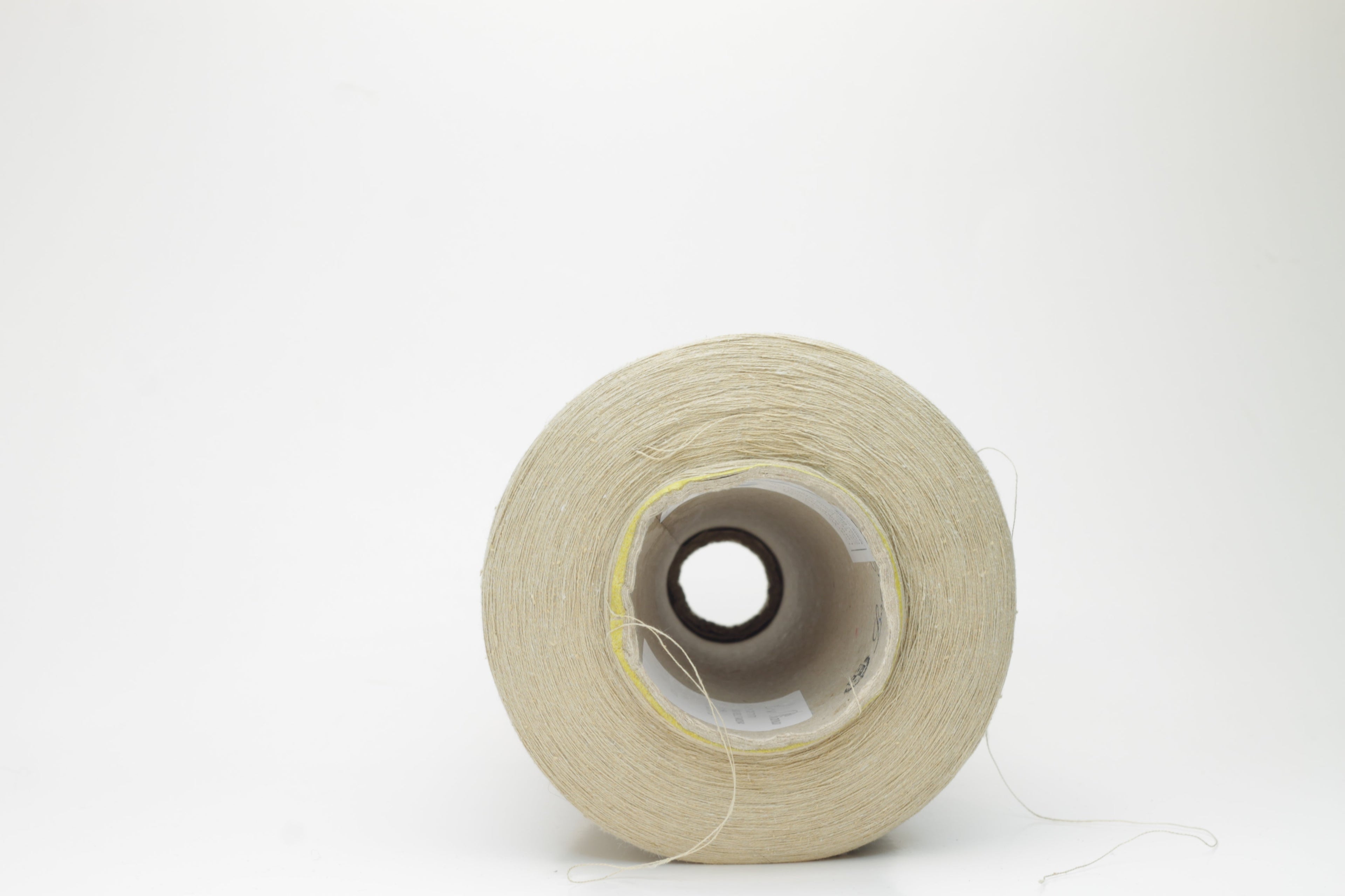 A skein of light beige yarn, showcasing a subtle sheen from the silk and a slight irregular texture from the linen fibers. The individual plies are gently twisted, creating a fluid, soft drape.