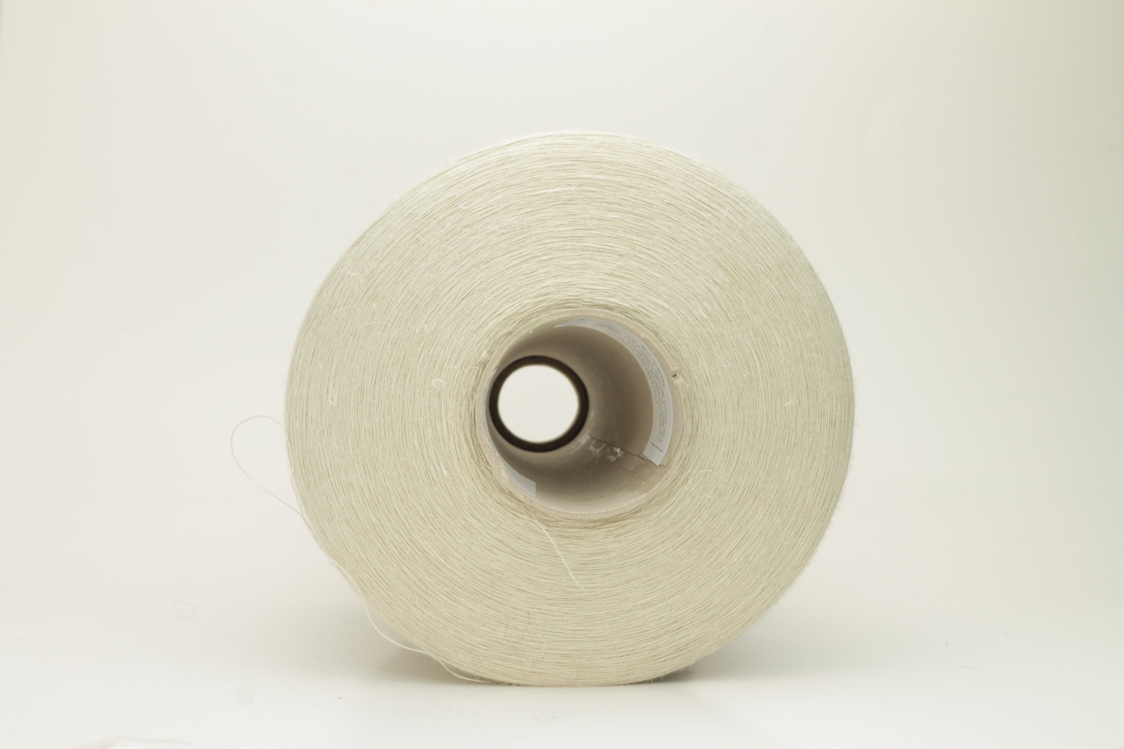 Close-up of a delicate, smoothly twisted light gray yarn strand, showing fine ply definition, subtle sheen, and gentle fluff.