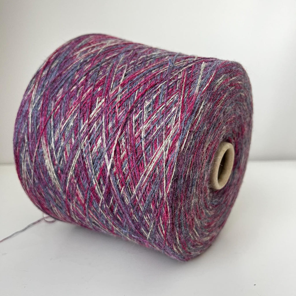 Close-up of soft, multi-ply blended yarn in variegated 'Stampa' shades, showcasing its delicate halo, subtle sheen, and gentle twist.