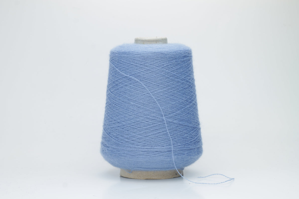 Close-up of a skein of soft, slightly fuzzy two-ply yarn in a deep, vibrant cerulean blue with a subtle, natural sheen.