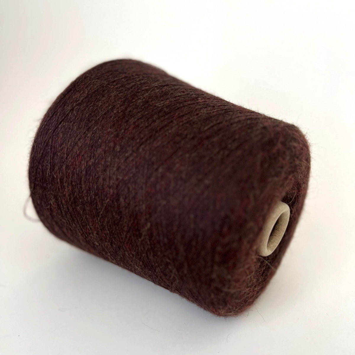 Soft, plush, deep marron brown yarn with a gentle, even twist, showcasing a subtle sheen and delicate halo. Neatly wound into a luxurious skein.
