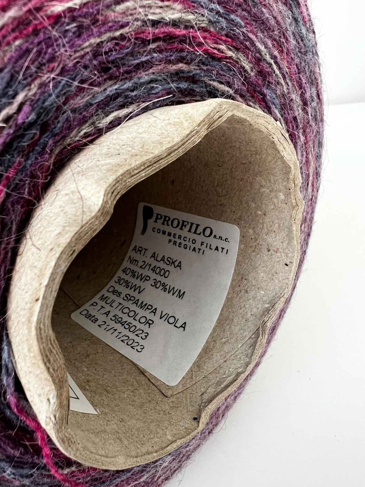 Close-up of soft, multi-ply blended yarn in variegated 'Stampa' shades, showcasing its delicate halo, subtle sheen, and gentle twist.