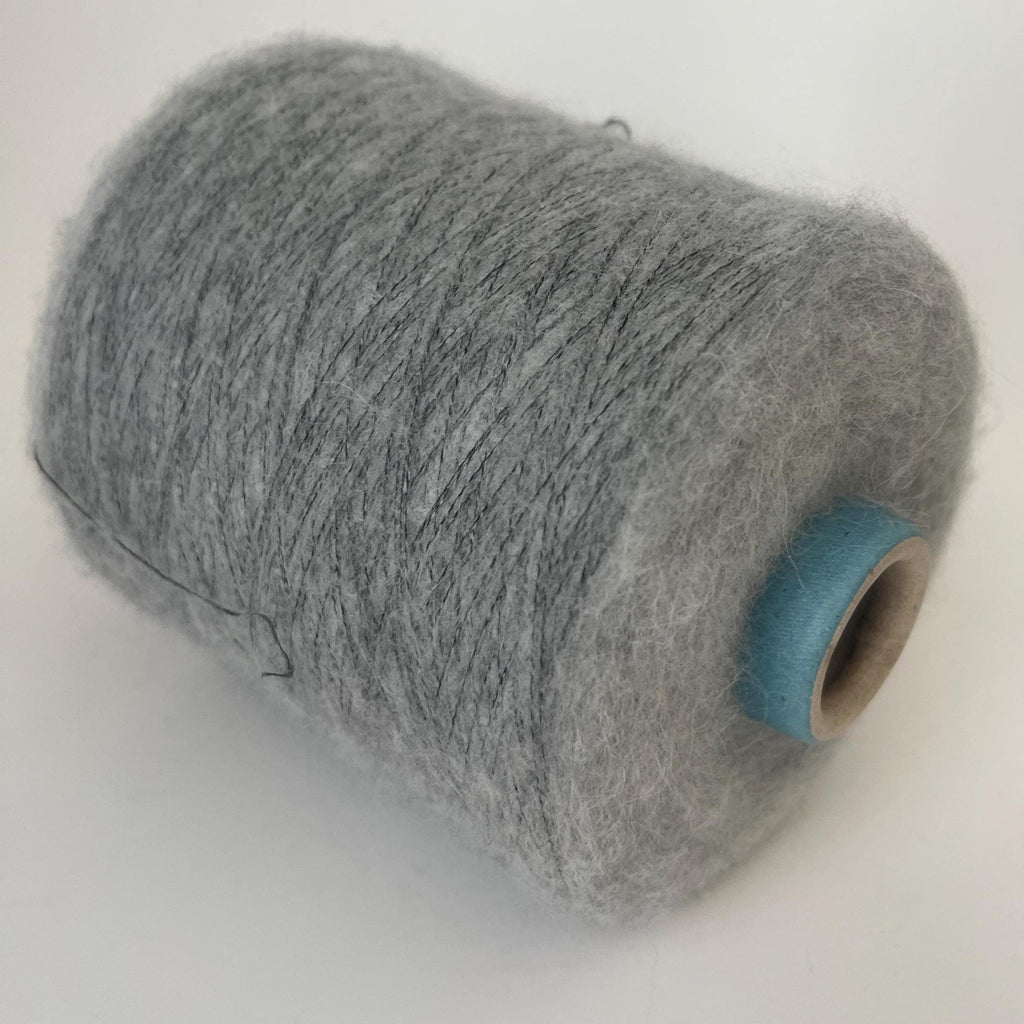 Finely spun, light gray yarn with a soft, visible fluffy halo. Ethereal, cloud-like texture and subtle sheen from premium alpaca fibers.